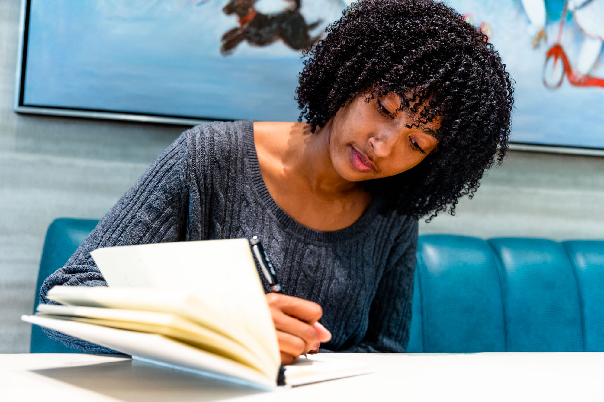 Young black woman writing in a notebook during a professional development program