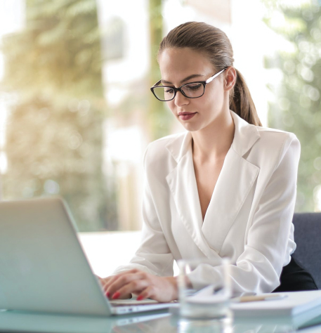 Professional young woman with glasses working on professional leadership program on computer