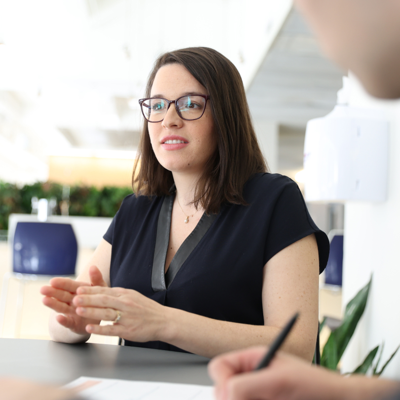 Young brunette woman with glasses explaining executive coaching