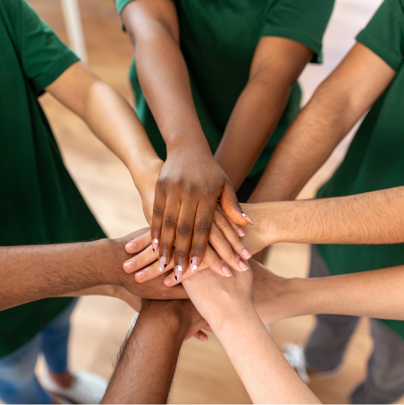 Diverse team's hands held together for nonprofit professional development